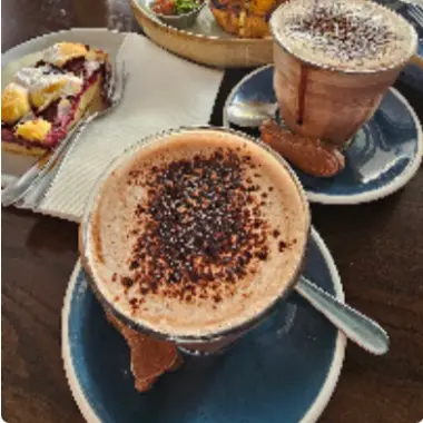 Two coffees dusted with chocolate on blue saucers